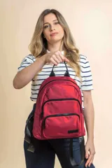 Mochila urbana de diseño funcional en color beige, confeccionada en tela impermeable. Cuenta con un compartimento principal amplio, un bolsillo secundario y un bolsillo frontal, todos con cierre. Incluye asa superior y correas ajustables para los hombros, con detalle de etiqueta de marca en el frente.