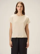 Remera negra de punto fino, con mangas cortas, cuello redondo y corte relajado. Cuenta con costuras verticales decorativas en el frente.
