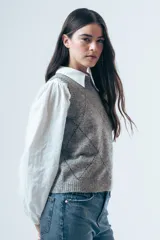 Chaleco de punto gris con diseño de rombos bordados en negro y cuello redondo. Presenta un corte clásico y tejido de textura suave.