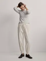 Pantalón jogger de sarga color beige, con cintura elástica ajustable con cordón y puños elásticos en los tobillos.