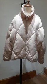Campera puffer color beige claro con relleno, cierre frontal y cuello alto.