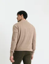 Remera de punto con medio cierre frontal, manga larga, cuello y puños en tejido canalé. Presenta un diseño con cierre metálico y detalle de puller en tono oliva.