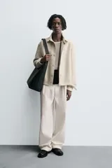 Sobrecamisa de hombre con corte relajado, confeccionada en tejido texturizado jaspeado en tonos beige y negro. Presenta cuello solapa, manga larga con puño de botón y cierre frontal de botonadura.