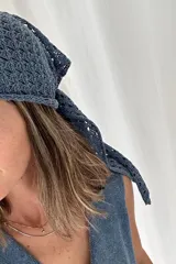 Bandana tejida artesanalmente en color azul, con diseño calado y terminaciones en ondas.