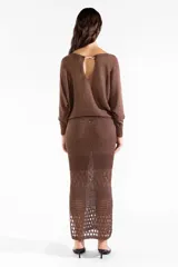 Falda midi tejida color marrón chocolate, con diseño calado en la parte inferior y tajo trasero.