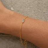 Pulsera dorada de plata 925 bañada en oro 18k, con piedra rectangular de topacio azul y otro topacio azul en el broche.