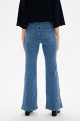 Pantalon de jean azul oscuro con corte flare, tiro alto y bolsillos frontales tipo parche.