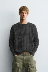 Jersey de corte relajado confeccionado en tejido de algodón con textura de trenzas. Presenta cuello redondo, manga larga y acabados en rib. Posee un efecto lavado que le otorga un aspecto único.