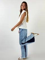 Pantalón de jean celeste con efecto lavado y parches de jean azul oscuro en los laterales.