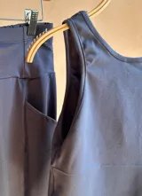 Conjunto negro de lycra de algodón, compuesto por un top corto sin mangas y un pantalón palazzo evasé con bolsillos laterales.