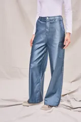 Pantalón cargo azul metalizado de corte wide leg y tiro medio, con bolsillos laterales y cierre frontal con botón y cremallera.