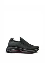 Championes deportivos modelo Lyra, de color negro con suela gruesa y cámara de aire integrada. Confeccionados en tejido knit elástico sin cordones para un calce fácil y cómodo.