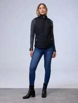 Chaleco negro capitoneado con abertura central con cierre, bolsillos delanteros con botones y forro de abrigo.