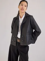 Campera tipo blazer de tela simil cuero, color negro, con cierre frontal de doble botonadura y solapas clásicas.