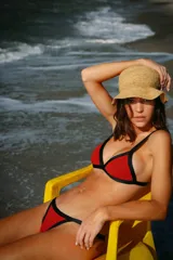 Conjunto de bikini rojo de lúrex con breteles y vivos negros. El corpiño es de triángulos fijos con breteles regulables y la bombacha es vedetina con breteles laterales regulables.