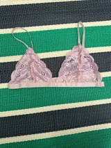 Soutien triángulo de encaje elastizado color rosa con corte al medio para dar forma al busto. Tiene elástico lencero satinado color avellana en el bajo busto y breteles finos de elástico lencero satinado color avellana con reguladores de metal.