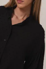 Camisa negra con textura de bolitas, manga globo y cuello camisero.