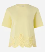 Blusa amarilla de mangas cortas con cuello redondo y bajo con flores bordadas.