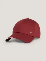 Gorra de béisbol de seis paneles color borgoña, confeccionada en algodón orgánico. Presenta ojales de ventilación, botón en la parte superior, costuras texturizadas en la visera, hebilla metálica ajustable en la parte trasera y logo metálico de Tommy Hilfiger en el frente.