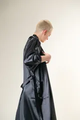 Bata larga de satén negro con mangas globo y lazo para atar en la cintura.