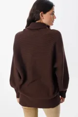 Sweater de punto con textura acanalada, cuello alto tipo polerón, mangas largas con diseño abuchonado y puños anchos.