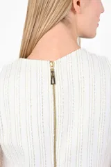 Vestido corto color blanco con hilos dorados, sin mangas y corte recto.