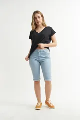 Pantalón capri de denim, color celeste claro, de tiro alto y corte ajustado, con dobladillo doblado en los tobillos.