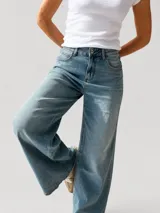 Pantalón de jean con corte wide leg y tiro medio-alto. Presenta un lavado gris azulado desgastado con acabado vintage y ruedo desflecado.