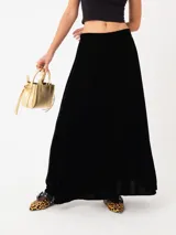 Falda larga de terciopelo negro, con silueta amplia y pretina elastizada.