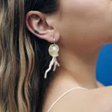 Aros colgantes con gancho plateado, dije de perla con forma de caracol y dije de coral blanco.