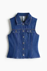Chaleco de denim azul rígido de algodón, con cuello camisero, cierre frontal de botones metálicos, bolsillos con solapa en el pecho y detalle de peplum en la parte inferior.
