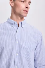 Camisa celeste con rayas verticales blancas, de lino, manga larga y corte clásico.