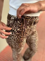 Cinto marrón con textura símil cuero, argollas plateadas y lazos de ajuste.