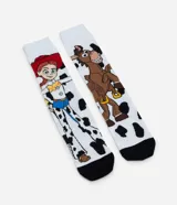 Par de medias de caña larga, blancas con estampado de vaca (manchas negras), con imágenes de los personajes Jessie y Bullseye de Toy Story. Tienen puntera y talón negros.