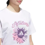 Remera de algodón blanca con cuello redondo y mangas cortas. Presenta un estampado frontal con el logo de Adidas sobre un diseño de flor en tonos lila y rosado.