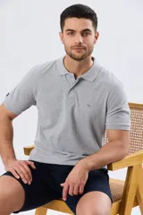 Remera polo lisa de piqué en color bordó, con cuello camisero, cierre frontal con botones y mangas cortas.