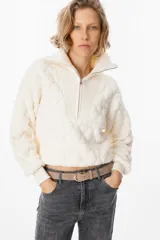 Sweater de textura acolchada en color beige, con cuello alto y cierre frontal parcial. Presenta puños y cuello en tejido acanalado, con un diseño de corte corto y holgado.