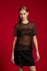 Remera marrón de manga corta y cuello redondo, confeccionada en poliéster con diseño completamente recubierto de lentejuelas.