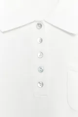 Top negro de punto fino con cuello polo, manga corta, cierre frontal de botones y un bolsillo de parche en el pecho.