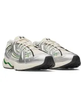 Championes deportivos de diseño retro-futurista, con base de malla color crema y superposiciones de cuero sintético metalizado plateado. Presenta detalles lineales en color verde y una entresuela robusta de EVA en tono crema con acentos verdes en el talón.