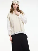 Chaleco de punto gris con escote en v y textura metalizada. Presenta mini tajos verticales en los laterales.