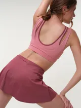 Falda short deportiva color bordó, con calza interna y bolsillo lateral, diseñada para brindar comodidad y libertad de movimiento.