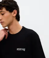 Remera de algodón color negro, con cuello redondo y mangas cortas. Presenta un diseño de calce holgado con una estampa pequeña en el pecho con el texto 'Forever Club Insiders Only'.