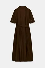 Vestido camisero midi color azul marino, con cuello solapa, escote pico y manga corta con vuelta. Presenta bolsillos laterales ocultos, solapas decorativas en el pecho, cinturón de lazo en el mismo tejido y cierre frontal con botones.