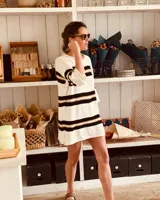 Vestido corto tejido en hilado de algodón con rayas horizontales negras y doradas sobre fondo blanco.