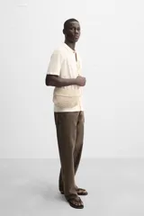 Bandolera color crudo confeccionada en tejido trenzado de algodón con cierre de solapa. El interior cuenta con un bolsillo plano y asa de hombro.