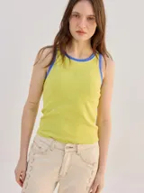 Musculosa básica de algodón color verde lima con puños y cuello ribeteados en azul, y sutil logo bordado en el centro del pecho.