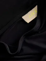 Top negro de un solo hombro, corte al cuerpo y diseño asimétrico que incluye una tira larga incorporada alrededor del cuello a modo de bufanda.