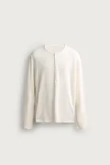 Remera polo de manga larga y calce regular fit en color blanco off-white, confeccionada en mezcla de algodón y lino, con cuello redondo y cartera con botonadura frontal.
