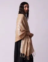 Pashmina gris con diseño a cuadros y flecos en los extremos.